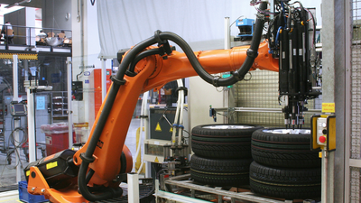 Kuka industrial robots gathering wheel bolts and rims from supply stations